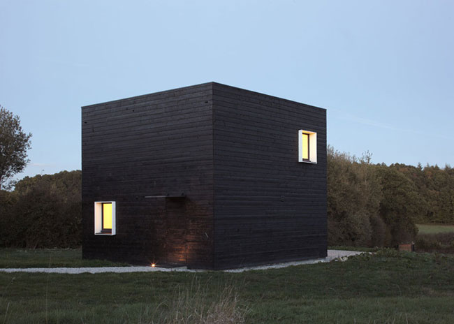 Vierkant zwart houten huis in Allemaal Dingen