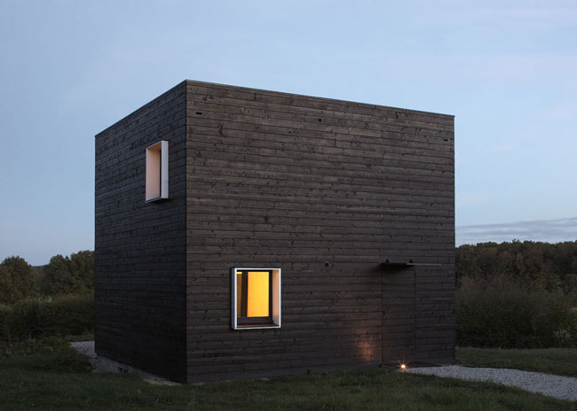 Vierkant zwart houten huis in Allemaal Dingen